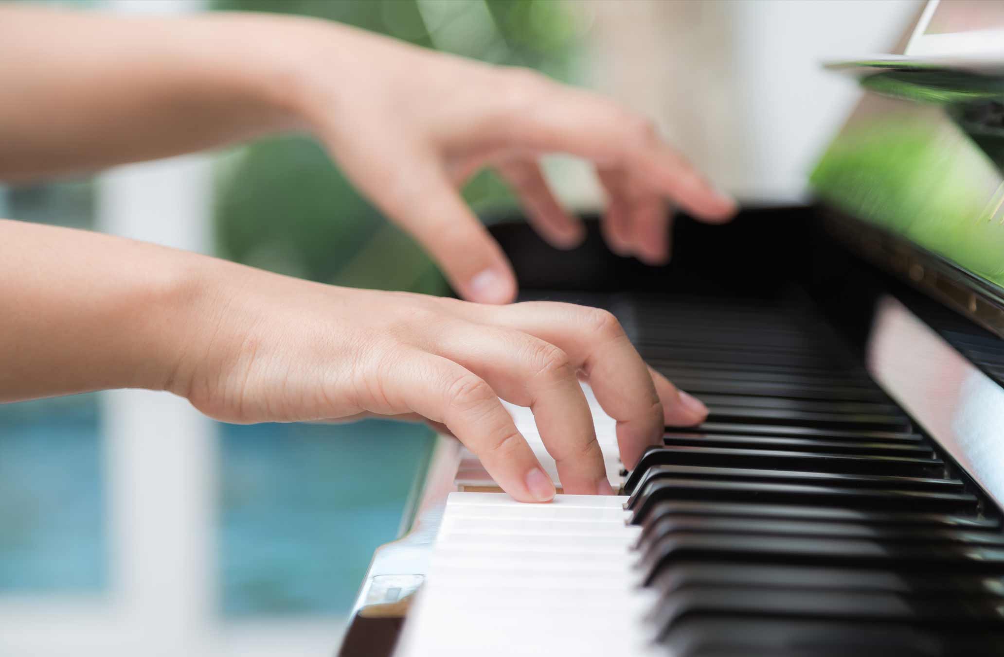 photo of hands on piano keys
